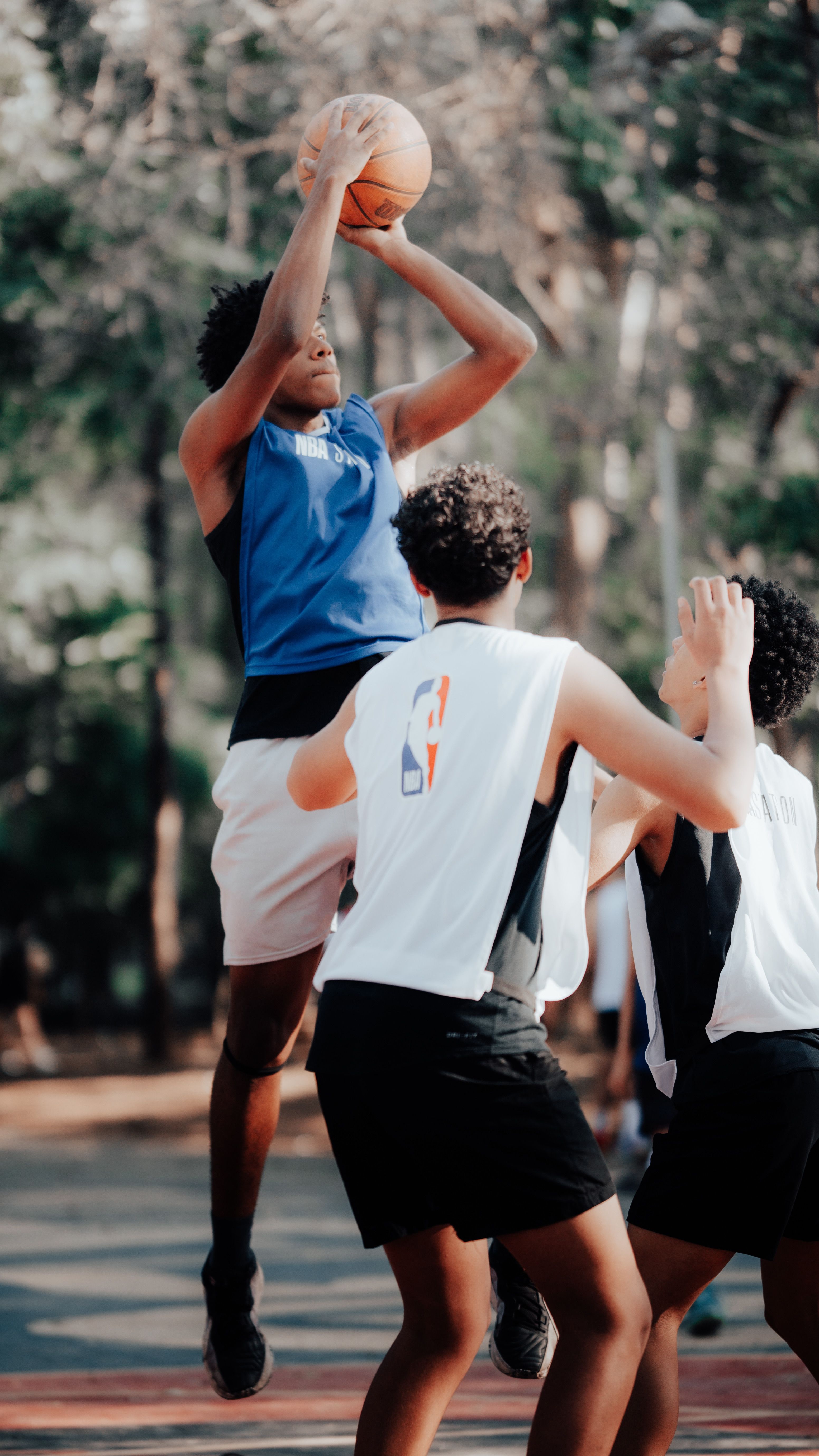 Unge, der spiller basketball udendørs