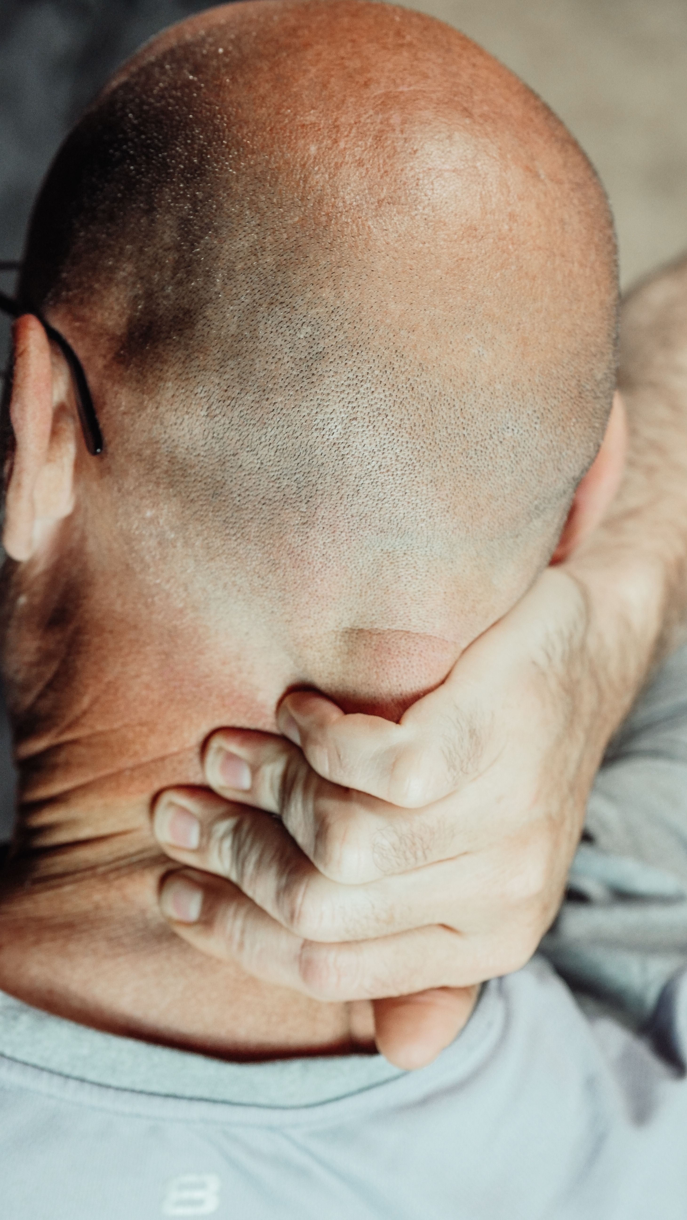 Person greift sich mit der Hand schmerzhaft an den Nacken